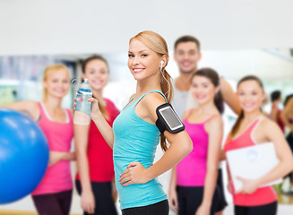 Image showing sporty woman running with smartphone and earphones