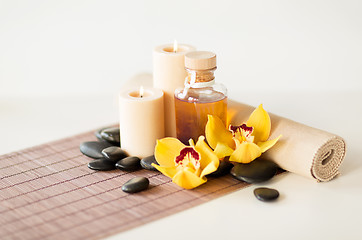 Image showing essential oil, massage stones and orchid flower