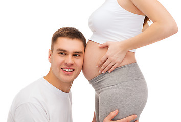 Image showing happy father listening belly of his pregnant wife