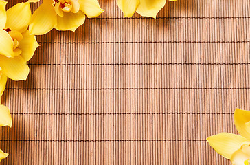Image showing closeup of orchid flowers on bamboo mat