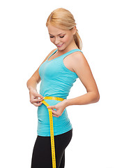 Image showing sporty woman with measuring tape