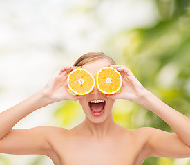 Image showing amazed young woman with orange slices