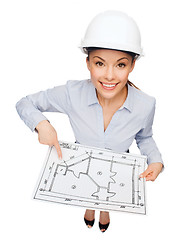 Image showing businesswoman in helmet showing with blueprint