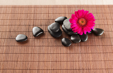 Image showing massage stones with flower on mat