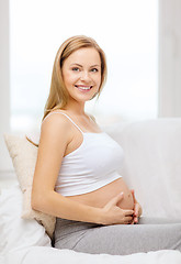 Image showing happy pregnant woman touching her belly