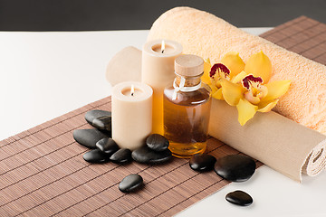 Image showing essential oil, massage stones and orchid flower