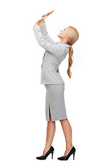 Image showing businesswoman pushing up something imaginary