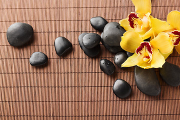 Image showing massage stones with flowers on mat