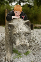 Image showing kid lying on a wooden lion