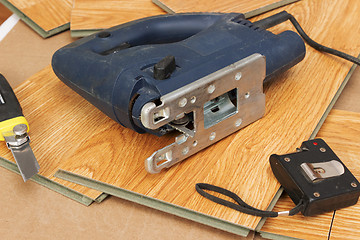 Image showing Master using an electric jigsaw saws laminated panel
