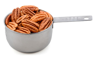 Image showing Whole pecan nuts in a metal cup measure