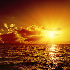 Image showing red dramatic sunset over dark water