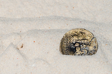 Image showing Ancient coin on white sand