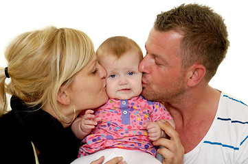 Image showing Mother and father are kissing baby