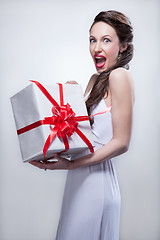 Image showing Young smiling woman holding gift