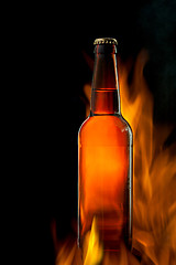 Image showing Beer bottle in fire on black