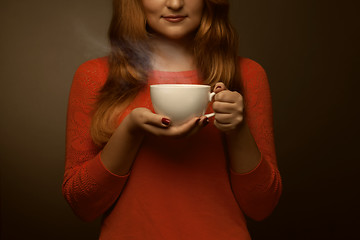 Image showing woman holding hot cup and smiles