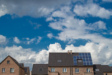 Image showing New houses with solar panels on roof under blue sky and clouds