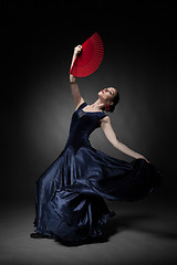 Image showing young woman dancing flamenco on black