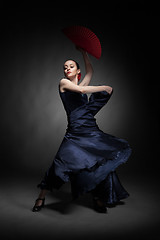 Image showing young woman dancing flamenco on black