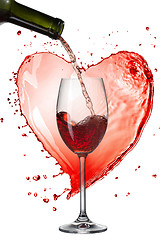 Image showing Red wine pouring into glass with splash against heart isolated o