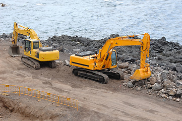 Image showing Two orange excavators