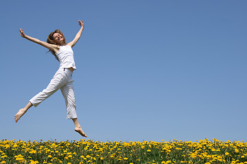 Image showing Pretty girl dancing in flowering meadow