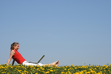 Image showing Young woman relaxing with laptop outdoors