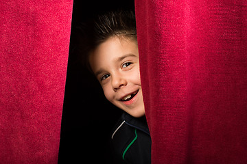 Image showing Child appearing beneath the curtain