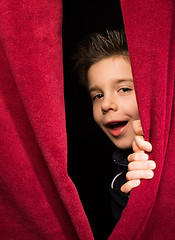 Image showing Child appearing beneath the curtain