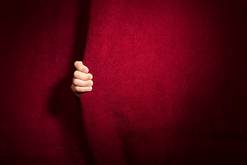 Image showing Hand appearing beneath the curtain.