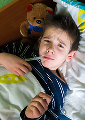 Image showing Sick child in bed with teddy bear