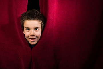 Image showing Child appearing beneath the curtain