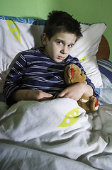 Image showing Sick child in bed with teddy bear