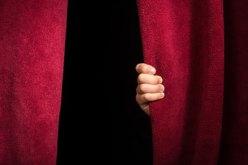 Image showing Hand appearing beneath the curtain.