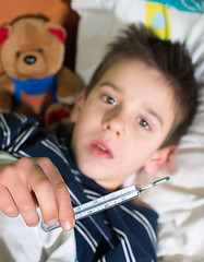 Image showing Sick child in bed with teddy bear