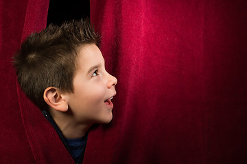 Image showing Child appearing beneath the curtain