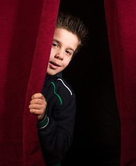 Image showing Child appearing beneath the curtain