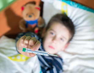 Image showing Sick child in bed with teddy bear