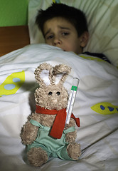 Image showing Sick child in bed with teddy bear