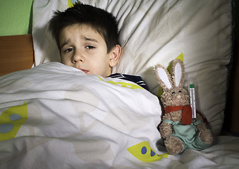 Image showing Sick child in bed with teddy bear