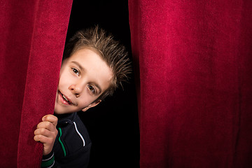 Image showing Child appearing beneath the curtain