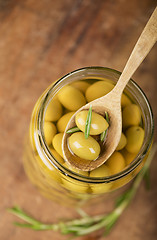 Image showing Close up green olives in bank,  rosemary