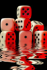 Image showing sinking pile of red illuminated white dice