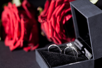 Image showing Engagement ring with a bunch of red roses