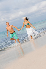 Image showing young happy couple walking on beach sunset holiday