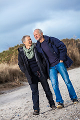 Image showing happy elderly senior couple walking on beach