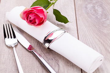 Image showing Table setting with a single pink rose