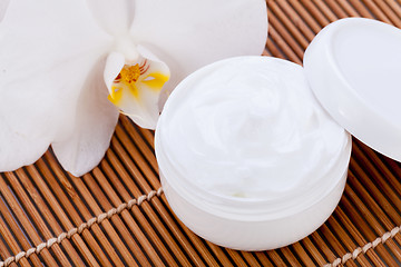 Image showing cosmetic face cream on wooden background 