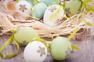 Image showing Colourful green Easter eggs in straw